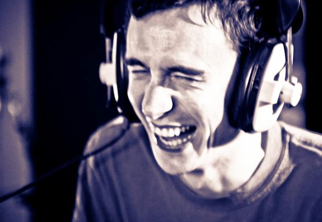 Jeremy wearing headphones and laughing in the recording studio